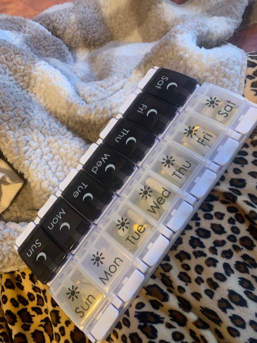 A weekly medication organizer on a kitchen counter